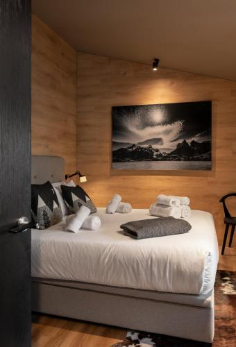a bedroom with a bed with white sheets and pillows at Luxury Summit Penthouse - Soldeu - By Ski Chalet Andorra in Soldeu