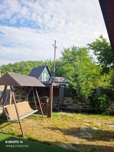a house with a porch and a swing at Quba A-Frame near Lake & Forest in Quba