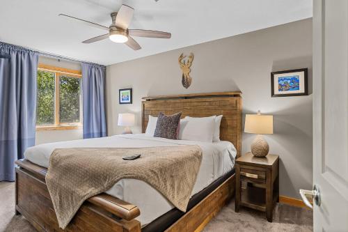 Un dormitorio con una cama y un ventilador de techo. en Creekside Downtown 2 Bedroom Condo managed by Little Sister Getaways, en Canmore