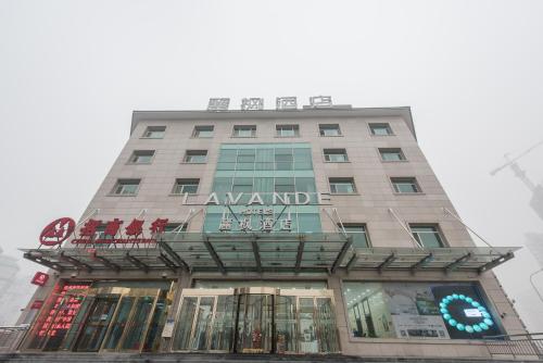 ein hohes Gebäude mit einem Schild darüber in der Unterkunft Lavande Hotel Beijing Asian Games Village in Peking