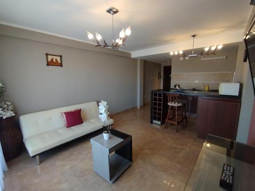 a living room with a couch and a kitchen at Casa Magno Apart Boutique in Salta