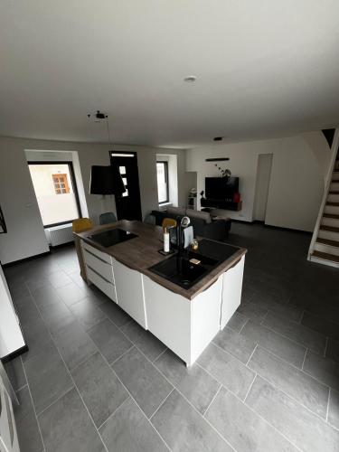 une cuisine avec un îlot au milieu d'un salon dans l'établissement Maison idéale pour le circuit des 24h, à Changé