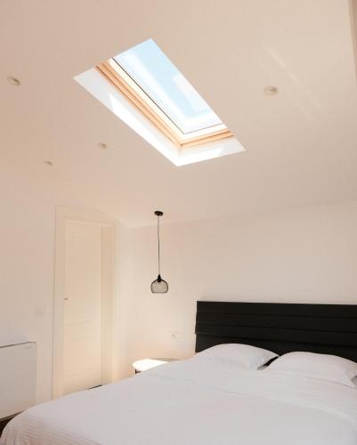 a bedroom with a bed and a skylight at Bianca Hotel & Villa in Tirana