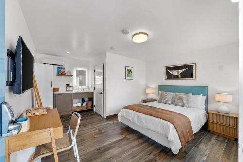 a bedroom with a bed and a desk and a tv at Surfhouse in Encinitas