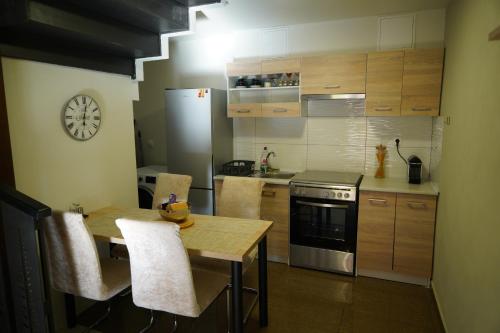 a kitchen with a table and a stove and a clock at Karditsa's Loft House in Kardítsa