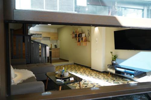 a living room with a couch and a tv at Karditsa's Loft House in Kardítsa