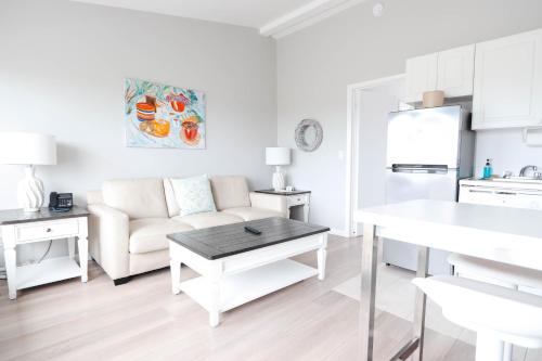a white living room with a couch and a table at Sea Crest in Amagansett