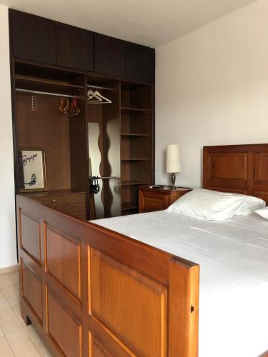 a bedroom with a large bed with a wooden headboard at House Under the Pines next to the sea in Mesochórion