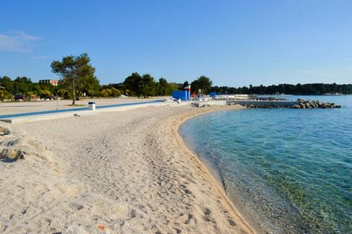 a beach with rocks and water and a pier at Apartment Zdravko in Štinjan