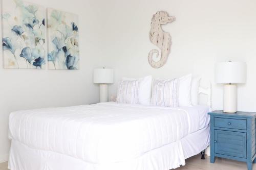 a bedroom with a white bed and a blue nightstand at Sea Crest in Amagansett