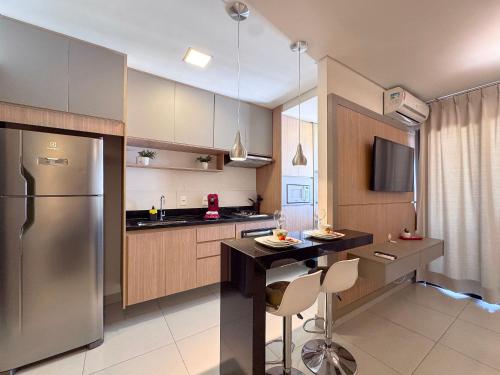 a kitchen with a stainless steel refrigerator and a table at Condomínio Residencial Unique Residence - São José do Rio Preto in Sao Jose do Rio Preto