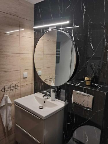 a bathroom with a sink and a mirror at Apartament MIODOWY przy plaży in Krynica Morska