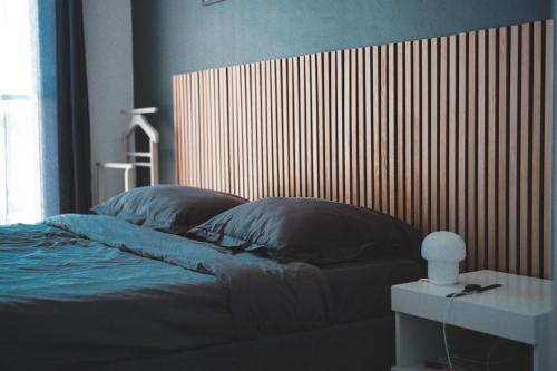 une chambre avec un lit avec une tête de lit en bois dans l'établissement Cozy & bright apartment, à La Celle-sous-Gouzon