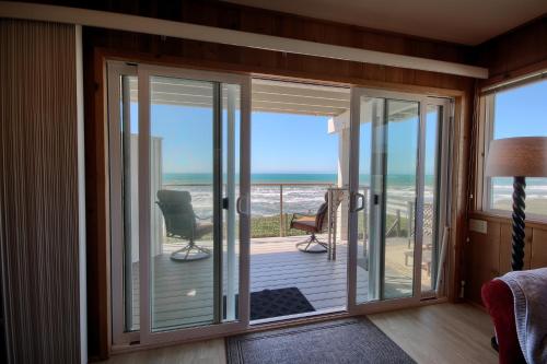 a room with sliding glass doors with a view of the ocean at Oceanfront Escape in San Simeon