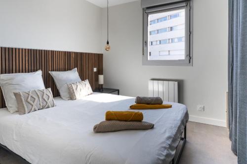 - une chambre avec un grand lit blanc et des oreillers dans l'établissement Délicieuse Parenthèse - Clim - Terrasse - Parking, à Toulouse