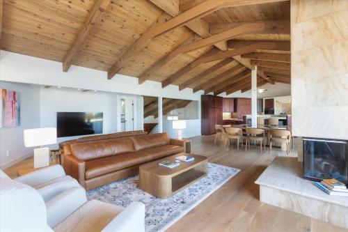 ein Wohnzimmer mit einem Ledersofa und einem Kamin in der Unterkunft Sunset Sanctuary Oceanfront Luxury Monthly Newly remodeled in Cambria