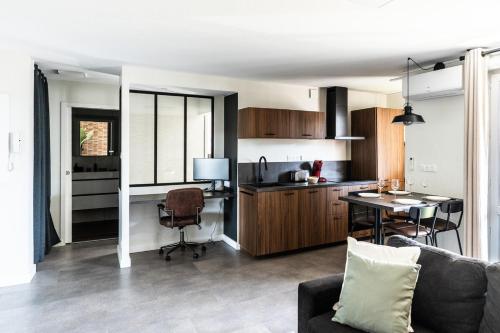 une cuisine et un salon avec un canapé et une table dans l'établissement Délicieuse Parenthèse - Clim - Terrasse - Parking, à Toulouse