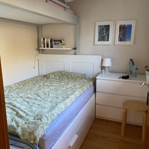 a small bedroom with a white bed and a desk at Schwedenhaeuschen-am-See-einfach-Lagom in Bistensee
