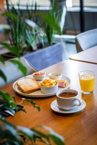 a table with breakfast foods and a cup of orange juice at Park Hotel in Punta del Este
