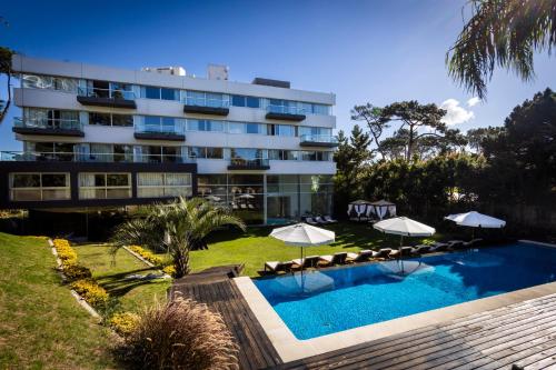a hotel with a swimming pool and umbrellas at Park Hotel in Punta del Este
