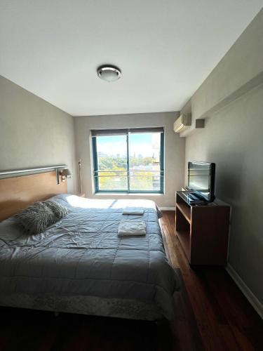 a bedroom with a large bed and a window at Precioso departamento en la mejor ubicación de Ciudad Mendoza, con piscina in Mendoza