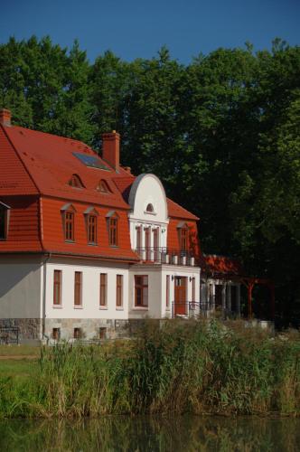 a large white house with an orange roof at Dwór Uradz in Uradz