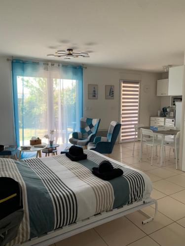 une chambre avec un grand lit et un salon dans l'établissement Ô Soleil - Spacieux studio entre mer & montagne parking wifi clim, à Saleilles