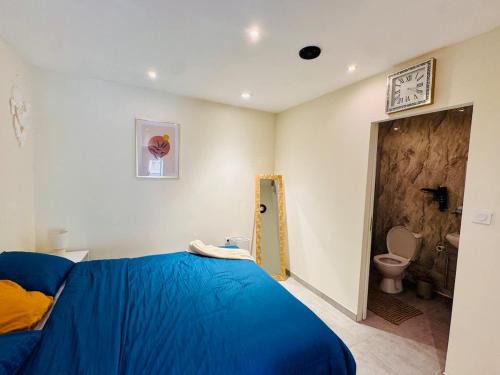 a bedroom with a blue bed and a toilet at Loft Bis cosy proche des plages et villes in Démouville