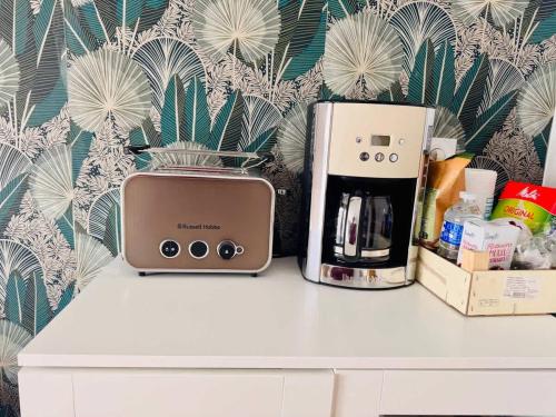 a counter with a toaster and a coffee maker on it at Loft Bis cosy proche des plages et villes in Démouville