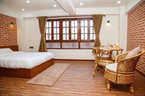 a bedroom with a bed and a table and chairs at Mandhah Heritage Home in Kathmandu