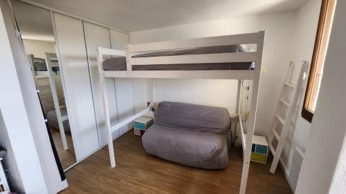 a small room with a bunk bed and a chair at Valberg Centre - Plaza - appartement vue montagne in Valberg