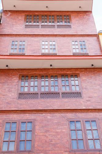 a tall red brick building with many windows at Mandhah Heritage Home in Kathmandu