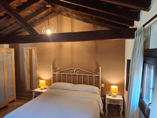 a bedroom with a large white bed with two lamps at Casas Recuero in Chinchón