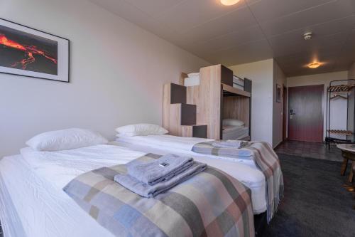 a hotel room with two beds with towels on them at Drangshlid Inn in Skogar