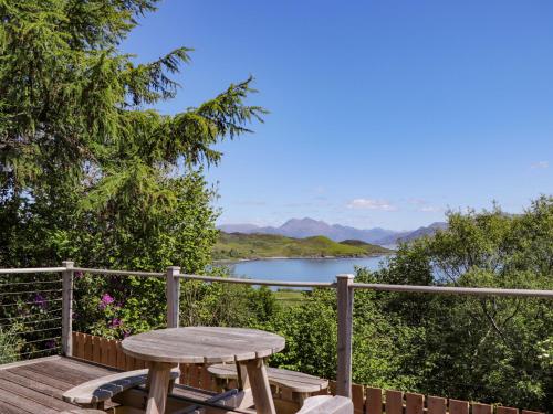 a wooden deck with a table and a view of a lake at The Lookout in Saasaig