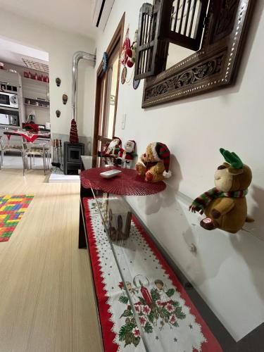 カネラにあるConfortável apartamento no centro de Canelaのリビングルームのガラスのカウンターに座っている2匹のテディベア