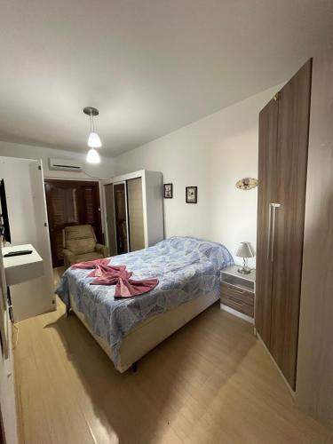 カネラにあるConfortável apartamento no centro de Canelaのベッドルーム1室(ピンクの弓が付いたベッド1台付)