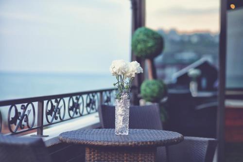 a vase with white flowers sitting on a table at My Suit Residence & Hotel in Samsun