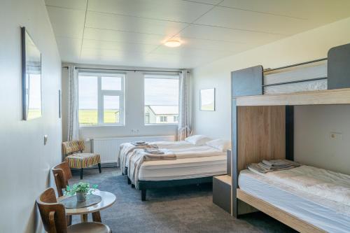 a bedroom with two bunk beds and a table and a chair at Drangshlid Inn in Skogar
