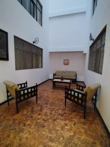 a living room with two chairs and a couch at Hotel Tomebamba Cuenca in Cuenca