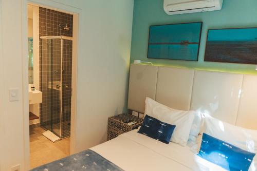 a hotel room with a bed and a shower at Wyndham Ilhabela Casa Di Sirena in Ilhabela