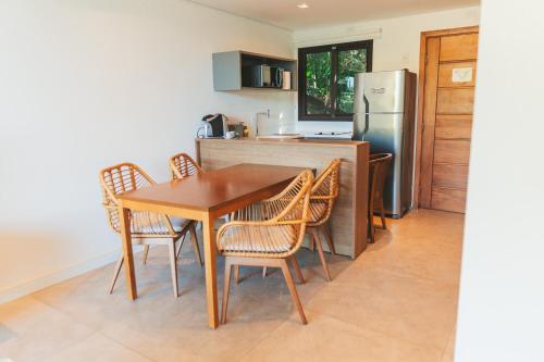 a kitchen with a table and chairs and a refrigerator at Wyndham Ilhabela Casa Di Sirena in Ilhabela
