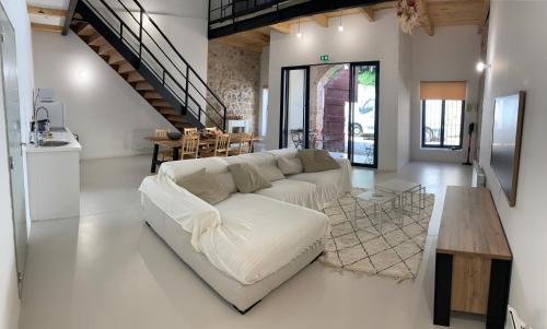 un salon avec un canapé blanc et une table dans l'établissement Loft Barjolais, à Barjols