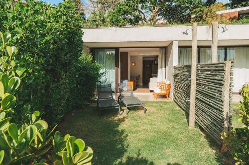 a group of chairs sitting on the grass in a yard at Wyndham Ilhabela Casa Di Sirena in Ilhabela