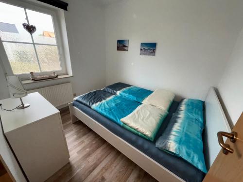 a small bedroom with a bed and a window at Ferienwohnung Charly in Carolinensiel