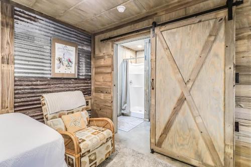 a barn door in a bedroom with a bed and a chair at Casas Coastal Experience Cabin C in Rockport
