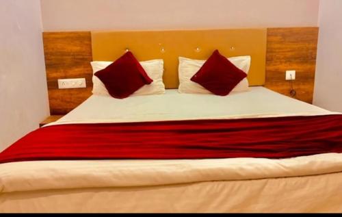 a bedroom with a large bed with red and white pillows at Shree aurora residency 900 metres from railway station and bus depo in Udaipur