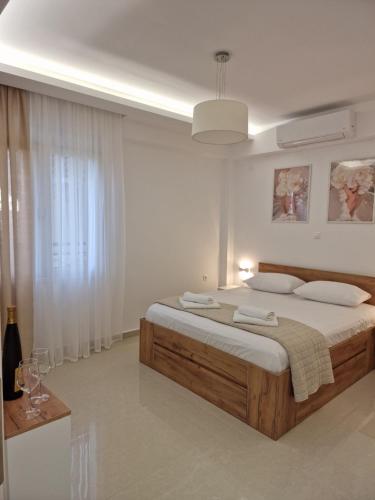 a white bedroom with a large bed and a window at Thomas & Lukas Apartment in Chania Town