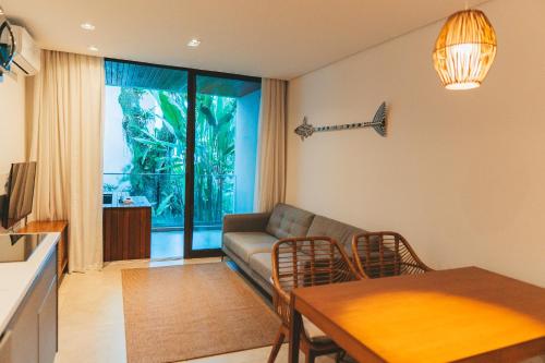 a living room with a couch and a table at Wyndham Ilhabela Casa Di Sirena in Ilhabela