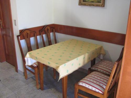 a table with two chairs and a table and a table and chairs at Soleil Apartmanok Baska in Baška